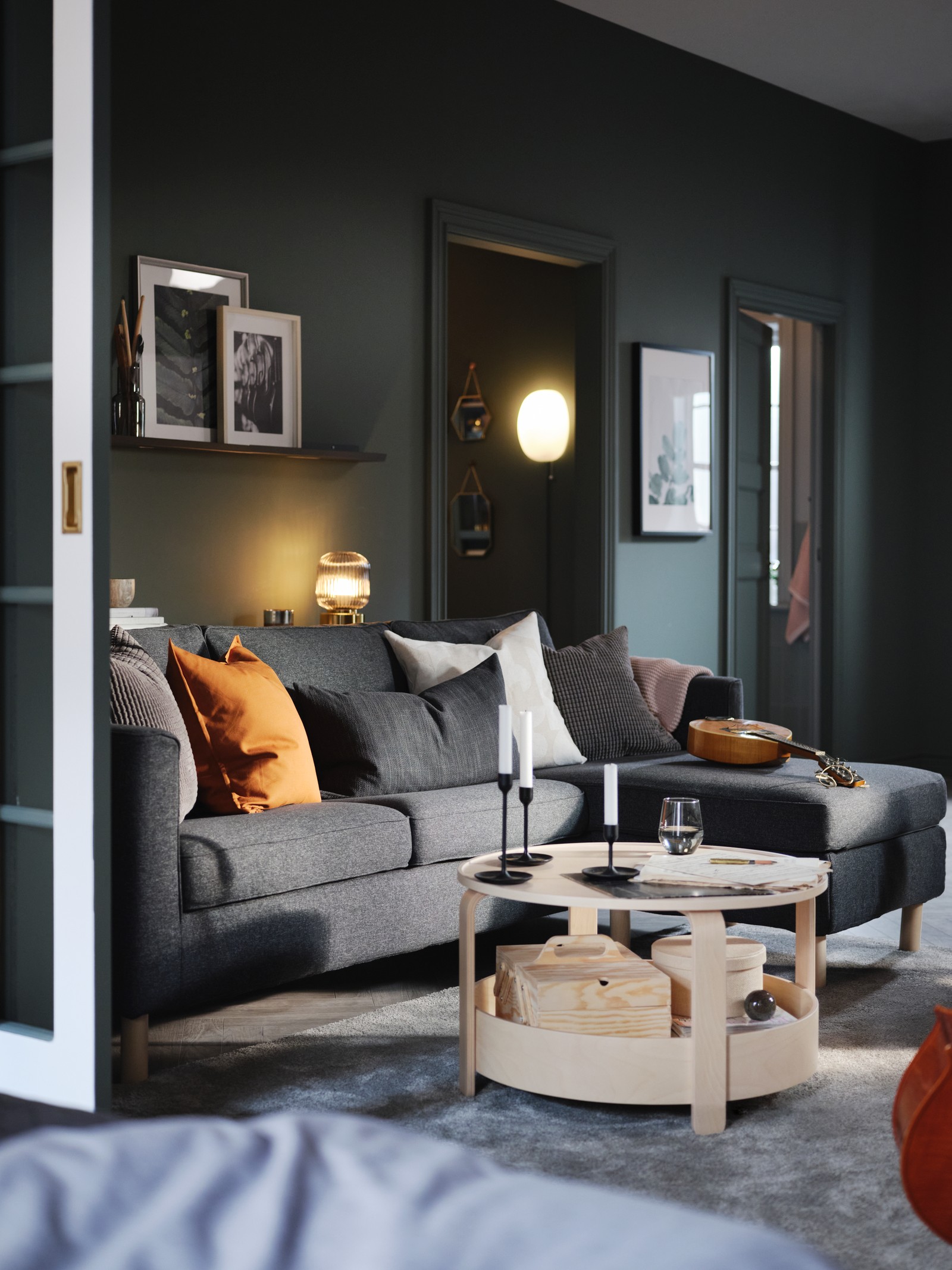A green living room with a dark-grey PÄRUP three-seat sofa with chaise longue, and a BORGEBY birch coffee table.