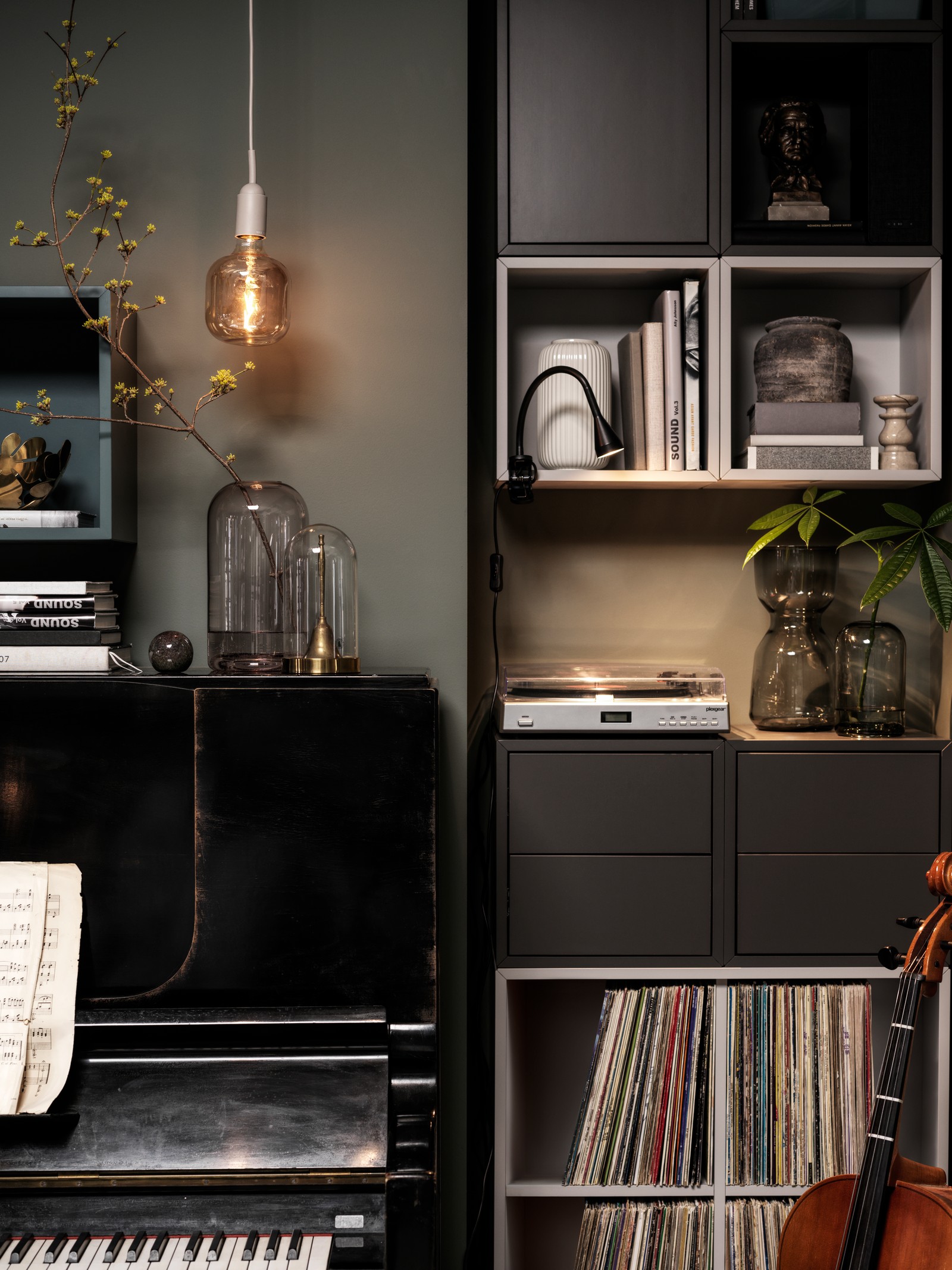 A piano and a vertical arrangement of EKET cabinets stand side by side. Free surfaces are dotted with decorative items.