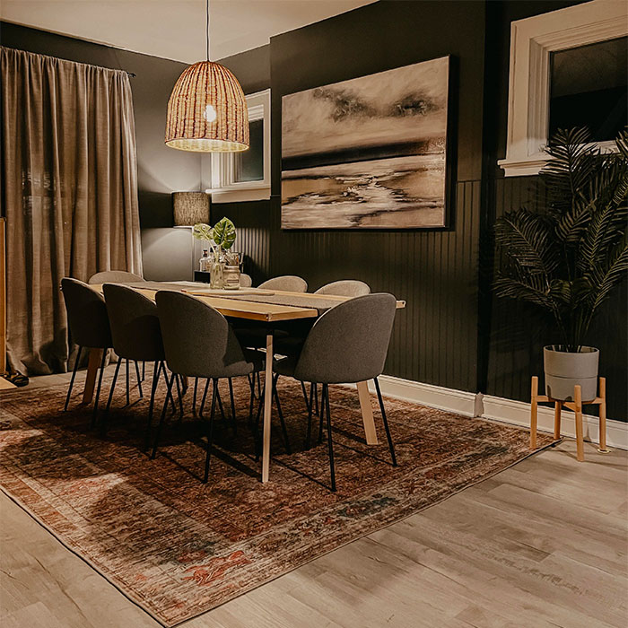 Black dining room with wooden table and chairs, featuring cozy lighting and elegant dining room ideas for family gatheri