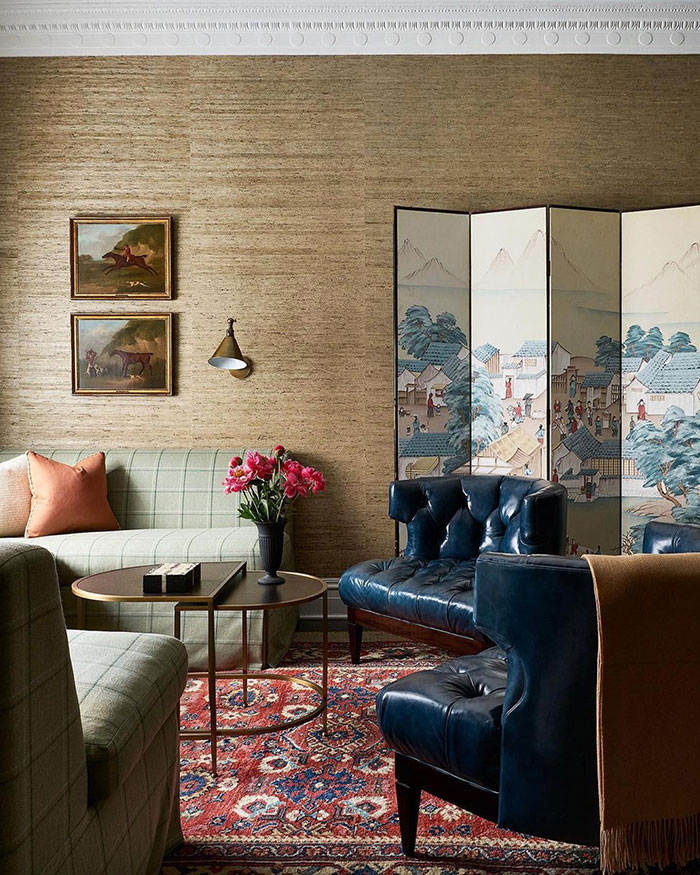 Spacious living room with vintage furniture, leather chairs, patterned rug, and floral accents showcasing home decor ide