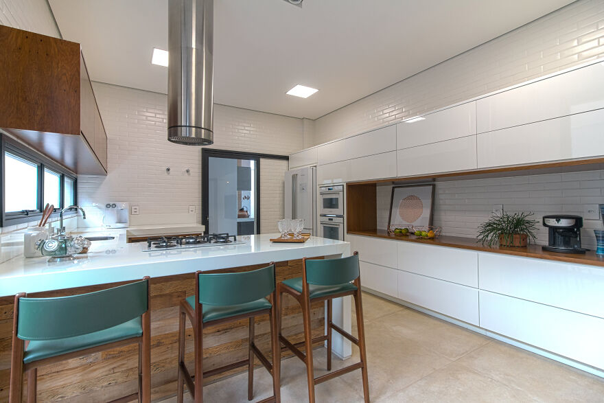 Modern and stylish horizontal upper kitchen cabinets in a bright, open kitchen with wood and white finishes.