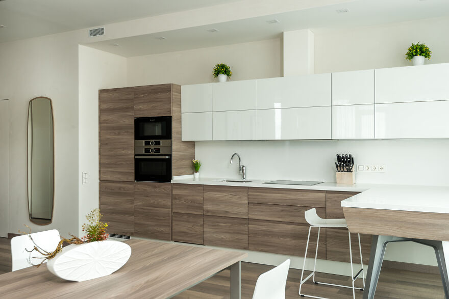 Modern kitchen cabinets combining wooden and white finishes in a stylish design for a sleek kitchen renovation idea.