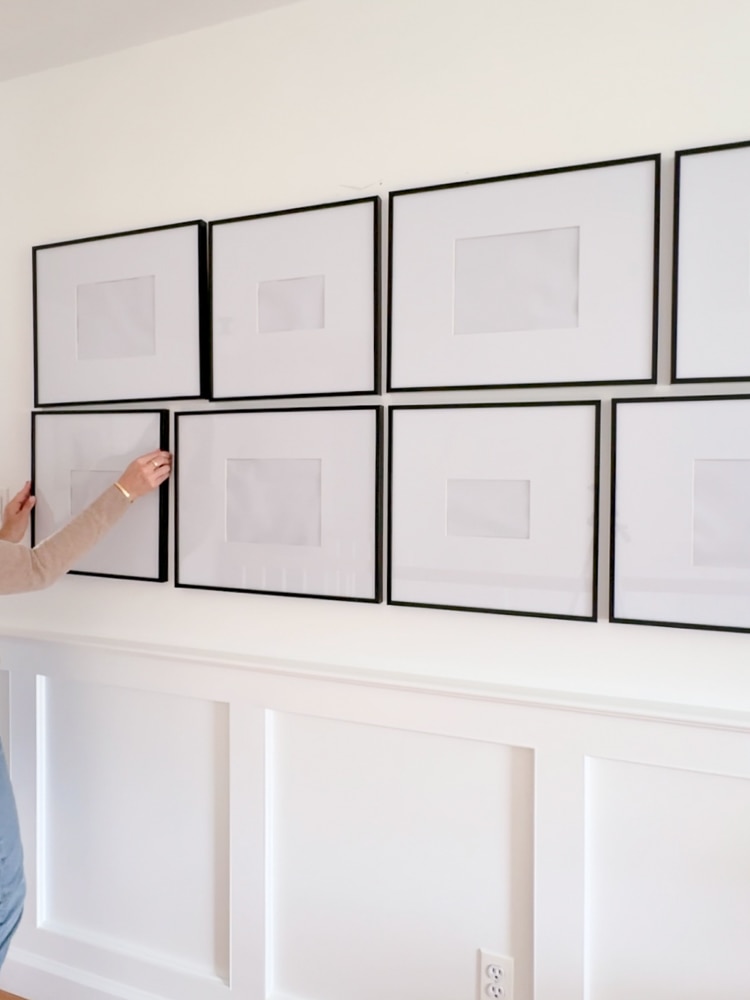 person hanging frames on the wall