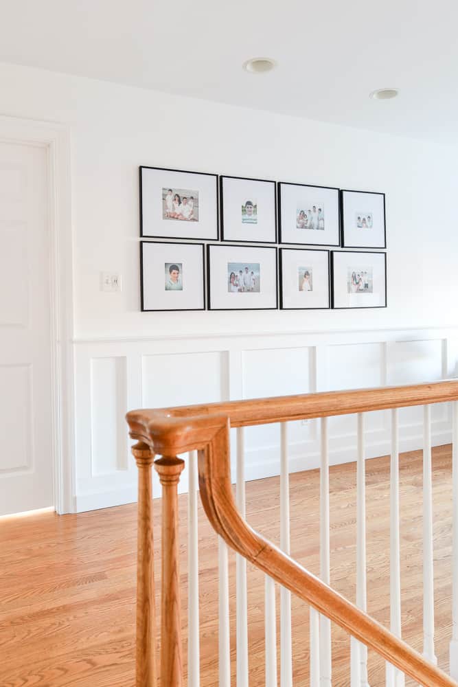 white walls with family photos in a grid pattern with black frames
