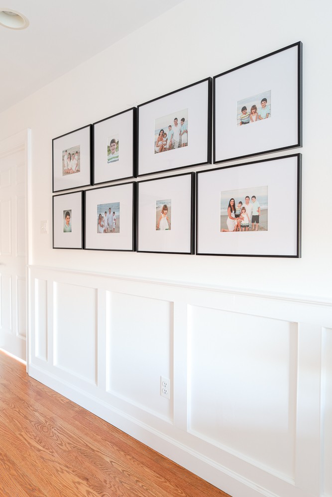 family photos hanging on the wall with black frames, large mattes